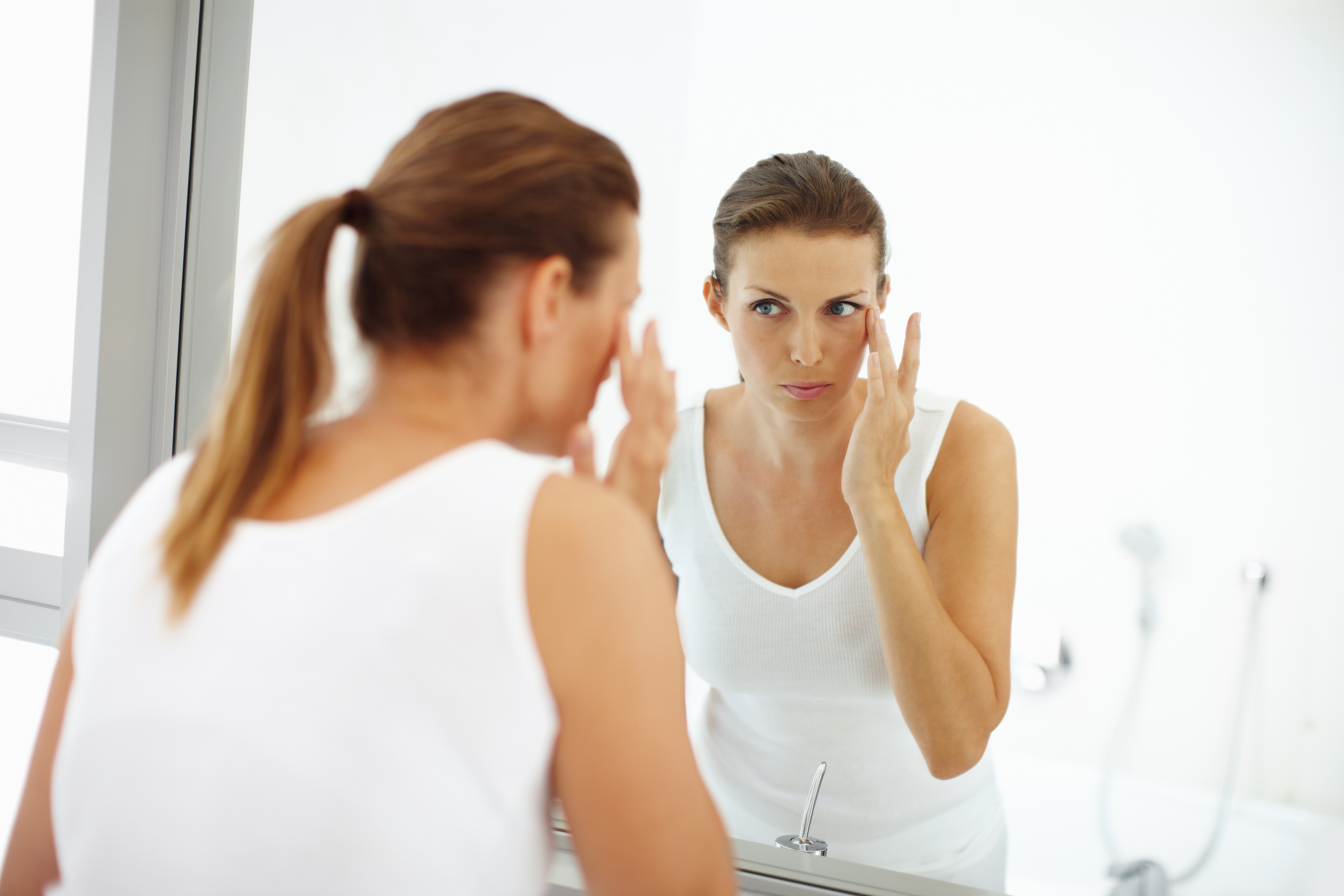 Image of Woman looking into mirror